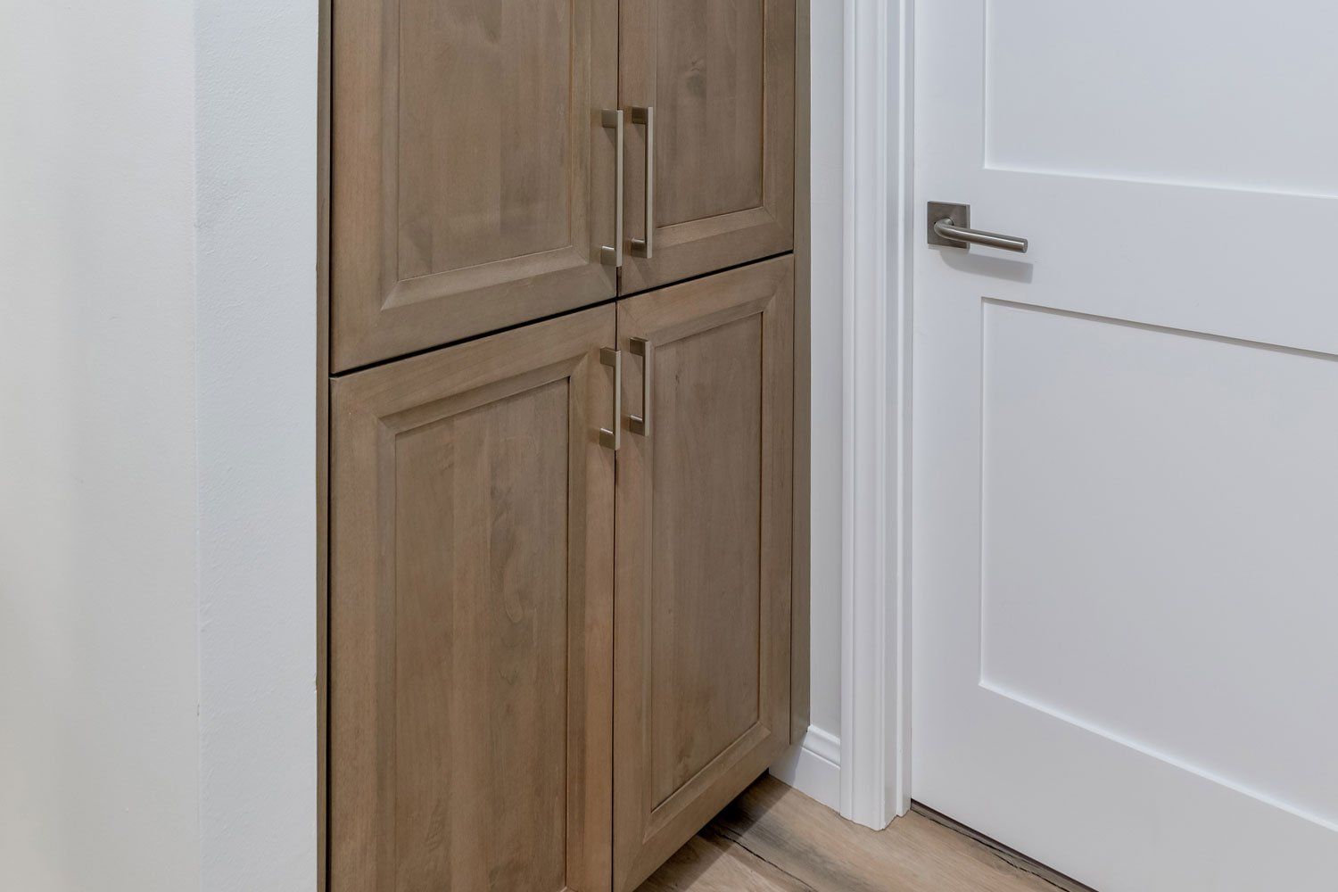 image shows a linen cabinet by Omega in light wood tones and a bedroom door, West Hills,CA Home Remodel 