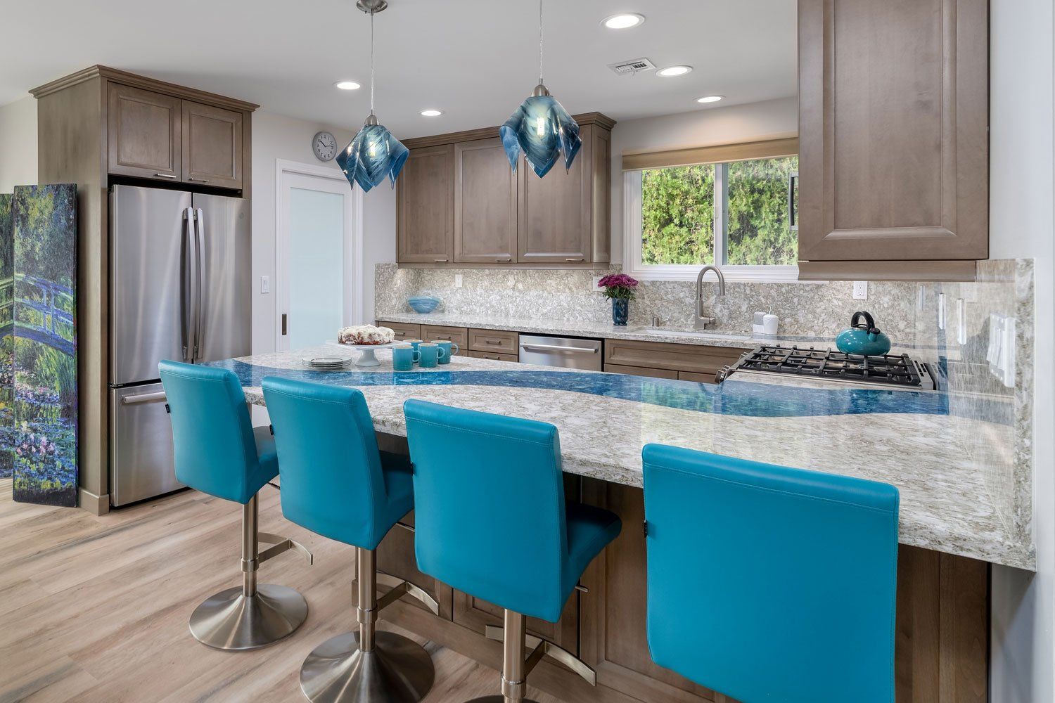 A kitchen with a long island and blue chairs.