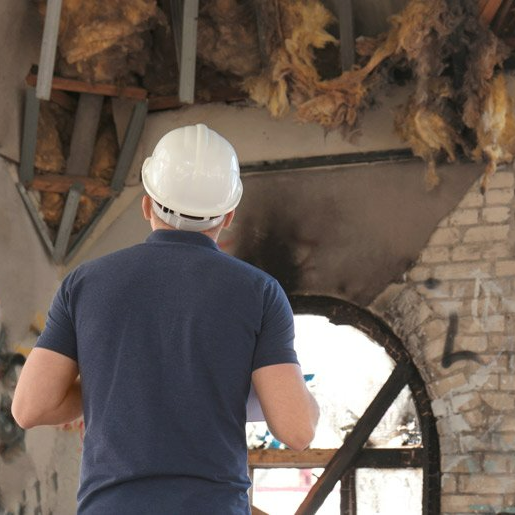 adjuster looking at house with damage