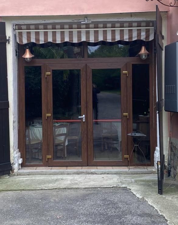 Una grande porta a vetri con una tenda a strisce sopra