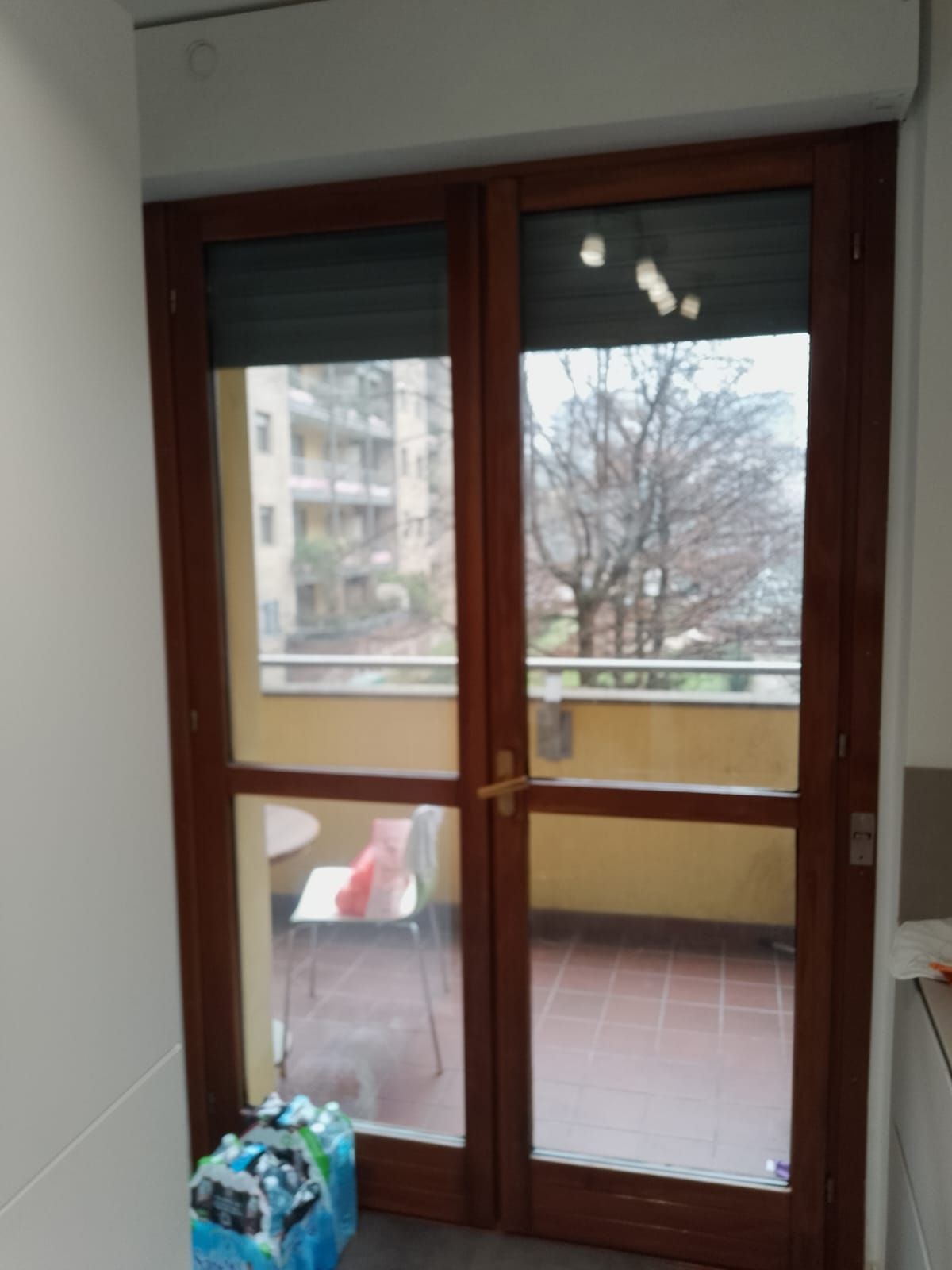 Una stanza con una porta scorrevole in vetro che conduce a un balcone