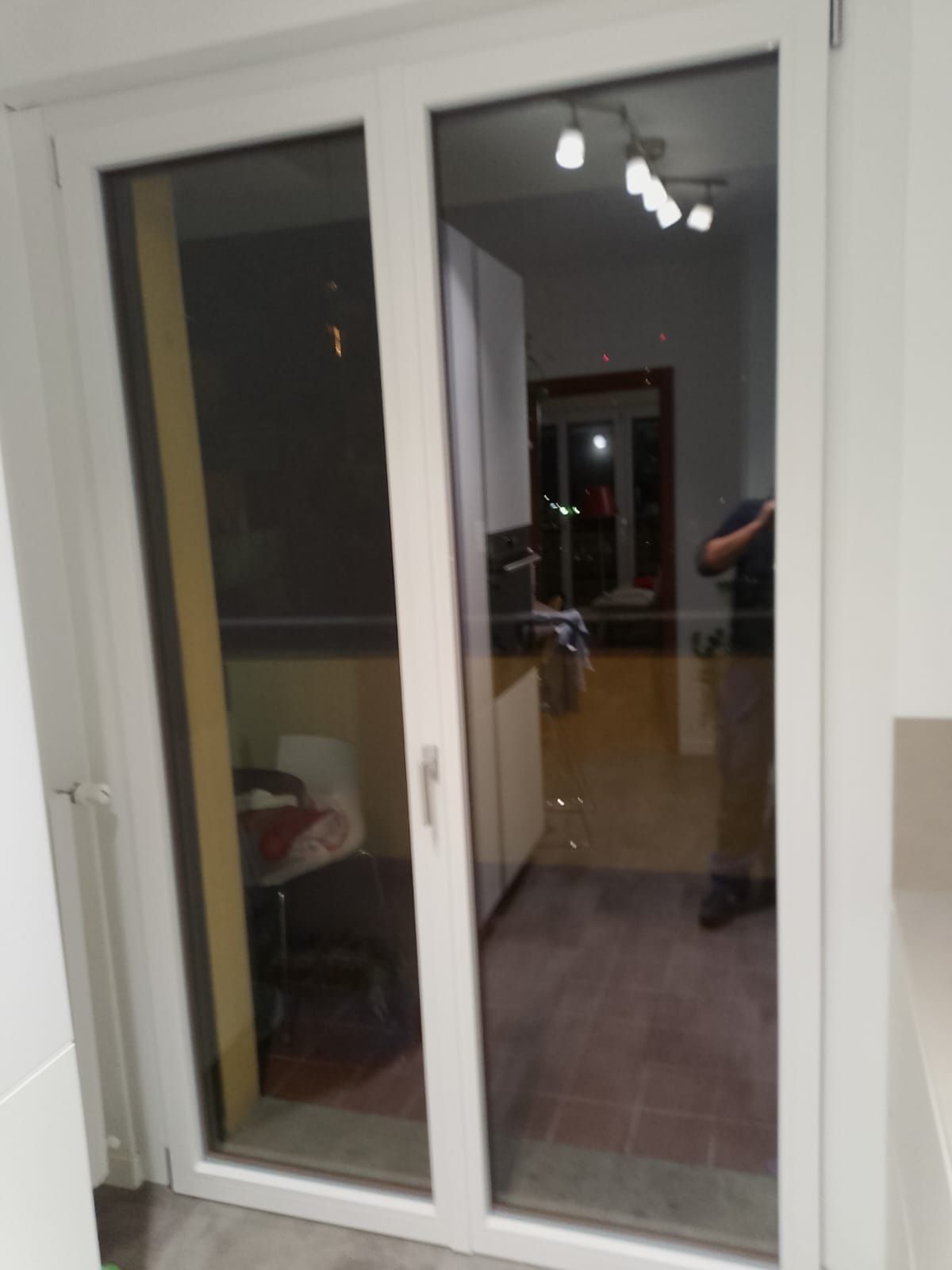 Un uomo è in piedi davanti a una porta a vetri in una cucina