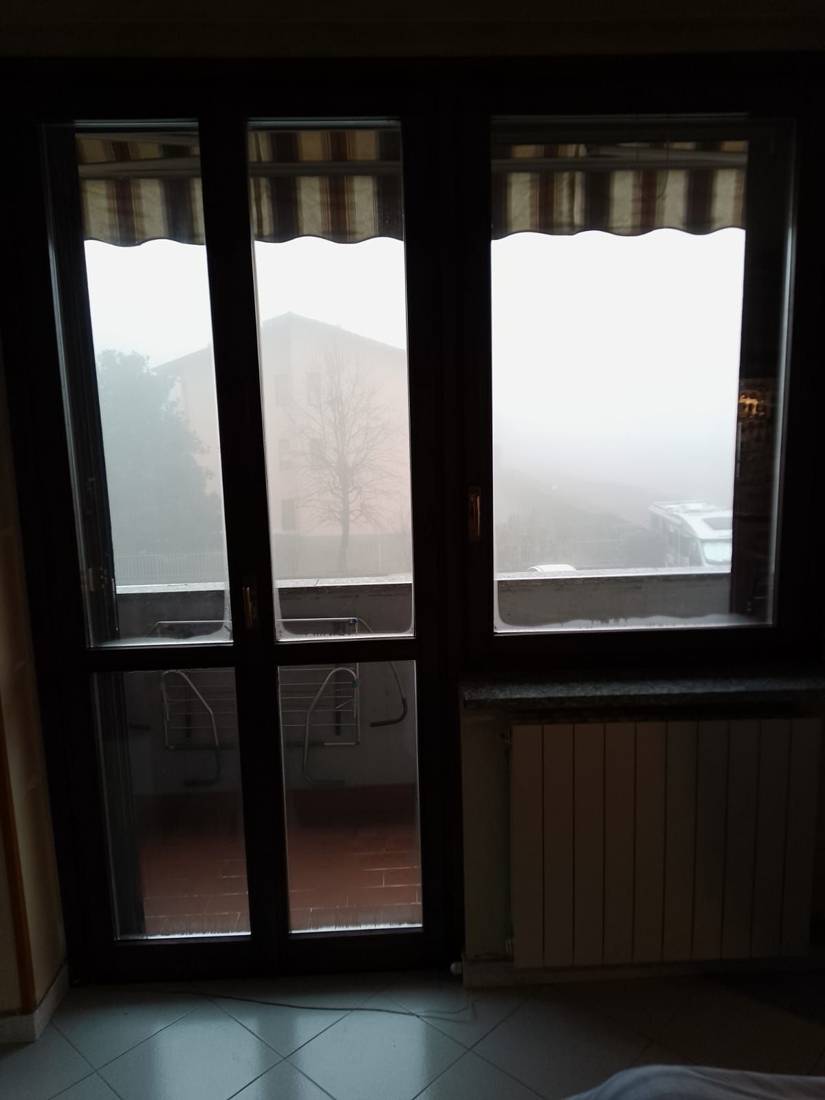 Una stanza con una porta scorrevole in vetro che conduce a un balcone