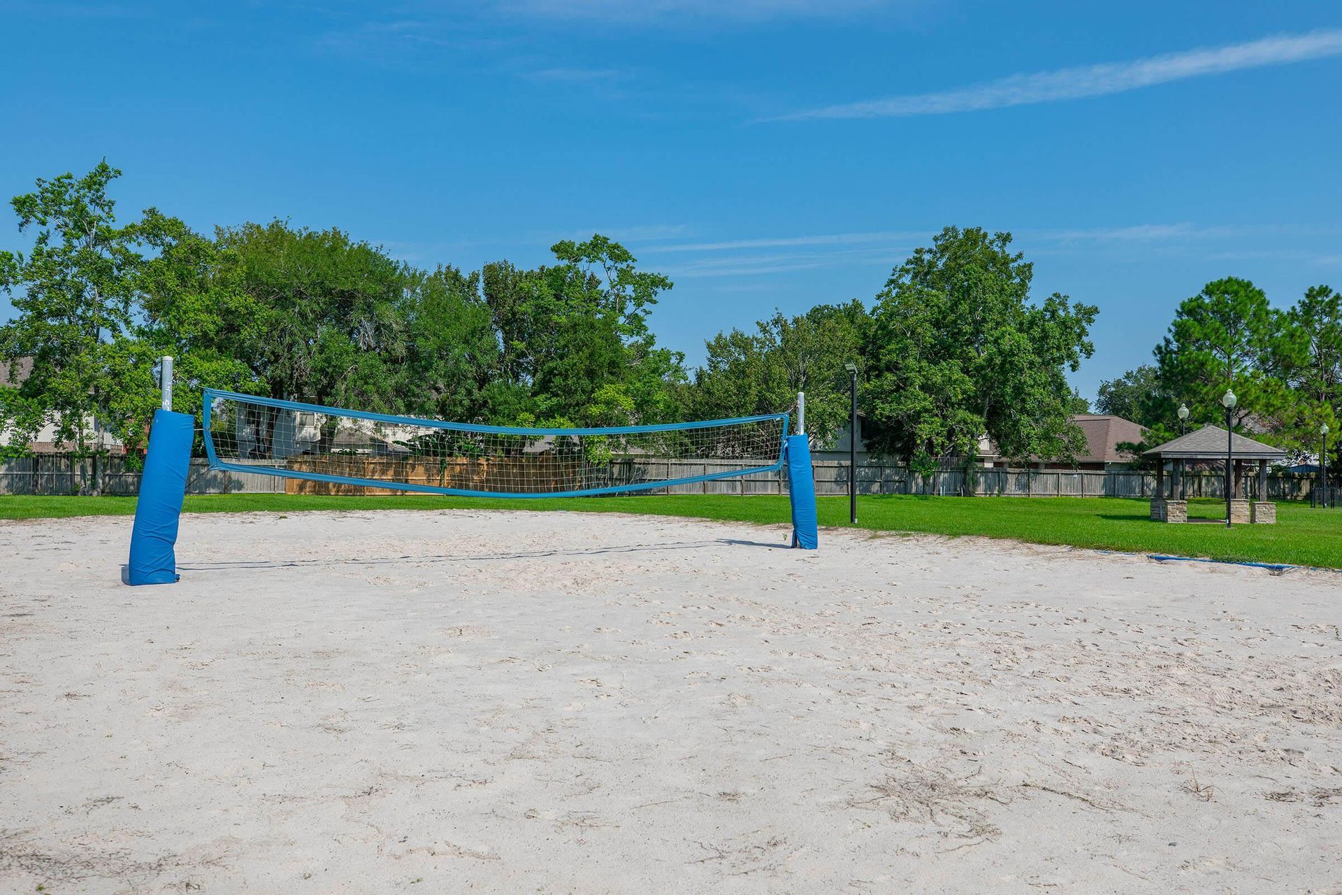An empty volleyball court in a park with trees in the background at Windsor Estates.