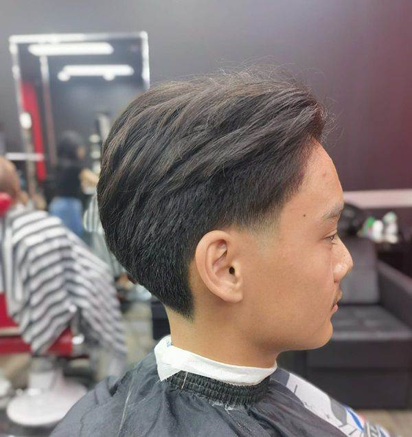 A Young Man is Getting His Hair Cut at a Barber Shop — Hair Obsession Barber in Nightcliff, NT