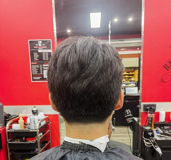 A Man With Straight Hair is Getting His Hair Cut at a Barber Shop — Hair Obsession Barber in Nightcliff, NT