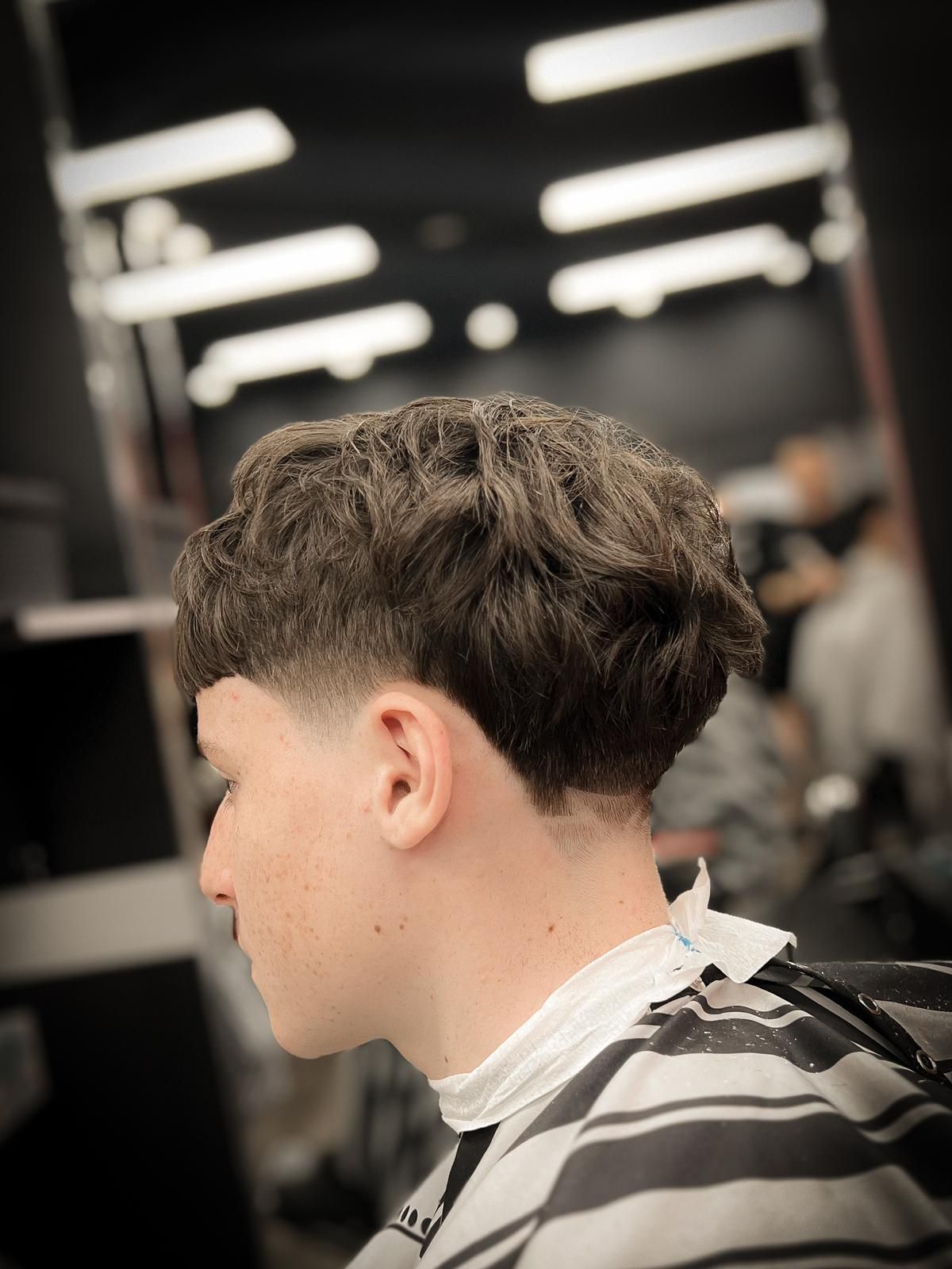 A Young Man is Getting His Hair Cut at a Barber Shop — Hair Obsession Barber in Nightcliff, NT