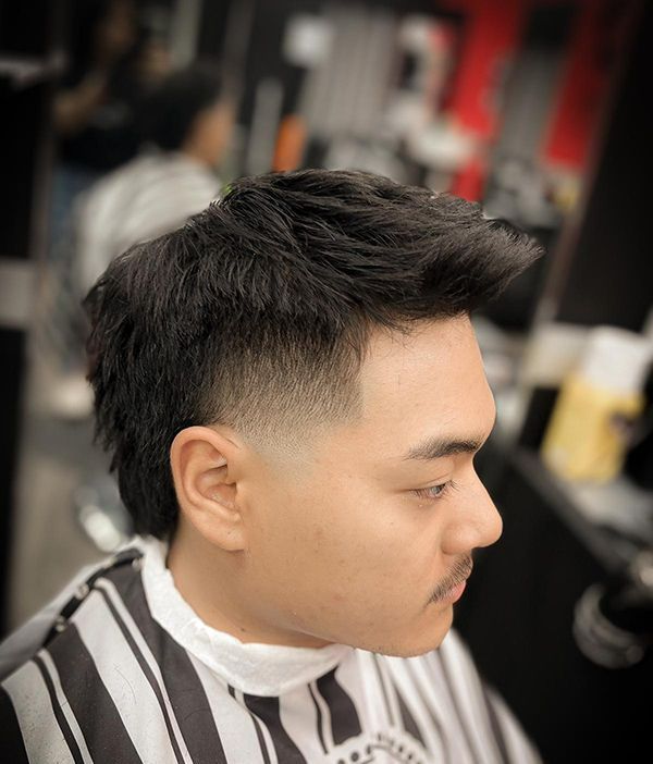 A Man With Stylish Hair is Getting His Hair Cut at a Barber Shop — Hair Obsession Barber in Nightcliff, NT