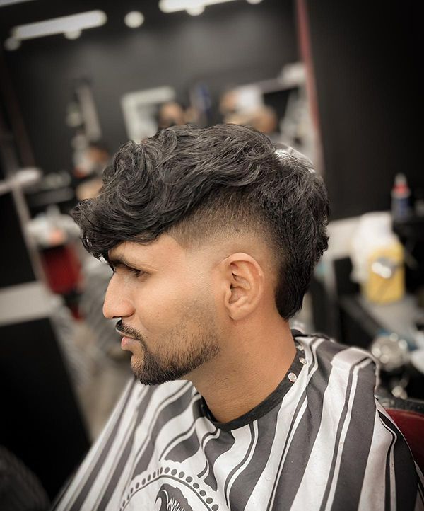 A Man With Wavy Hair is Getting His Hair Cut at a Barber Shop — Hair Obsession Barber in Nightcliff, NT