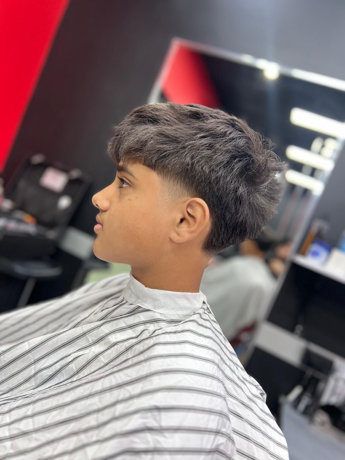 A Young Boy is Getting His Hair Cut at a Barber Shop — Hair Obsession Barber in Nightcliff, NT