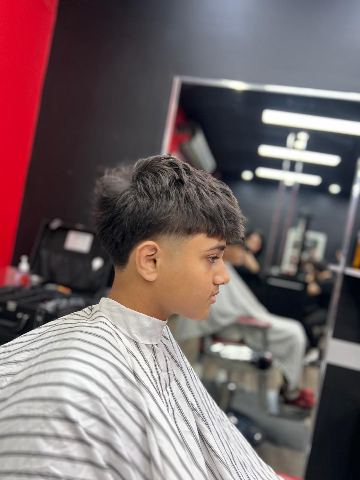 A Young Boy is Getting His Hair Cut at a Barber Shop — Hair Obsession Barber in Nightcliff, NT