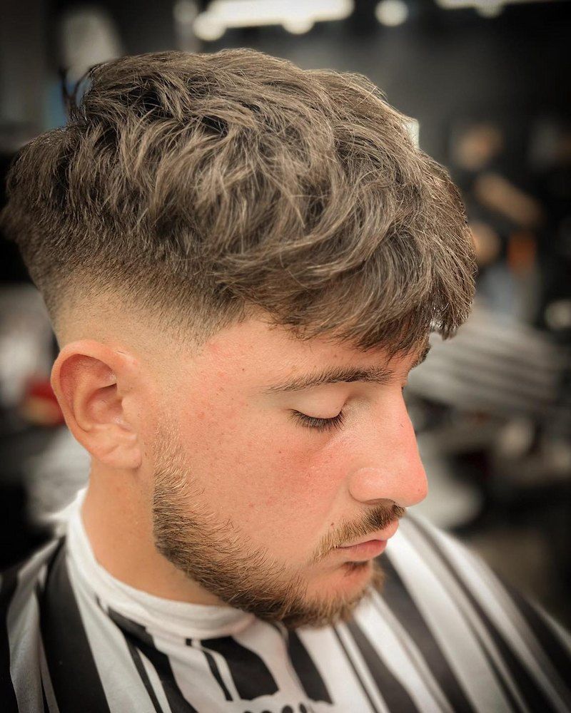 A Bearded Man With a Faded Haircut is Getting a Trim at a Barbershop — Hair Obsession Barber in Nightcliff, NT