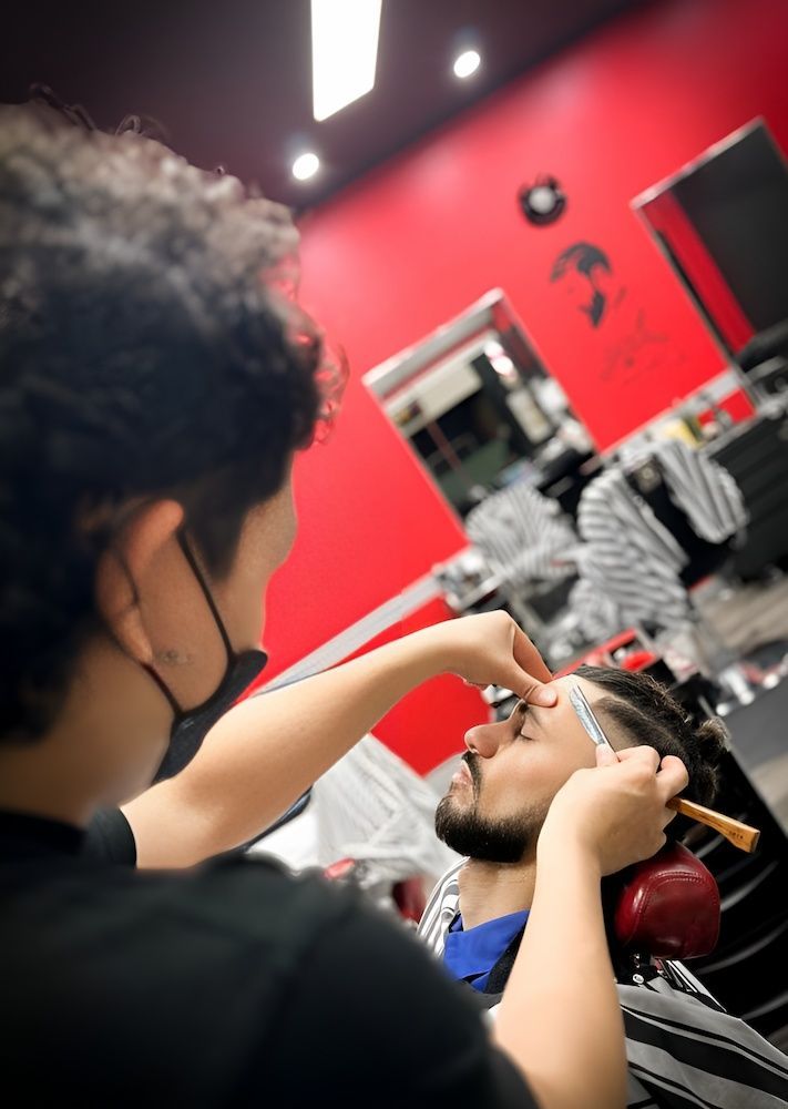 A Man is Getting His Beard Shaved by a Barber in a Barber Shop — Hair Obsession Barber in Nightcliff, NT