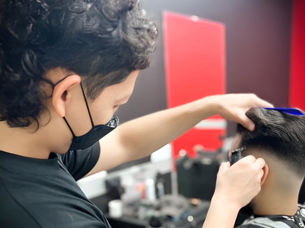 A Barber Wearing a Protective Mask is Styling a Man's Hair — Hair Obsession Barber in Nightcliff, NT