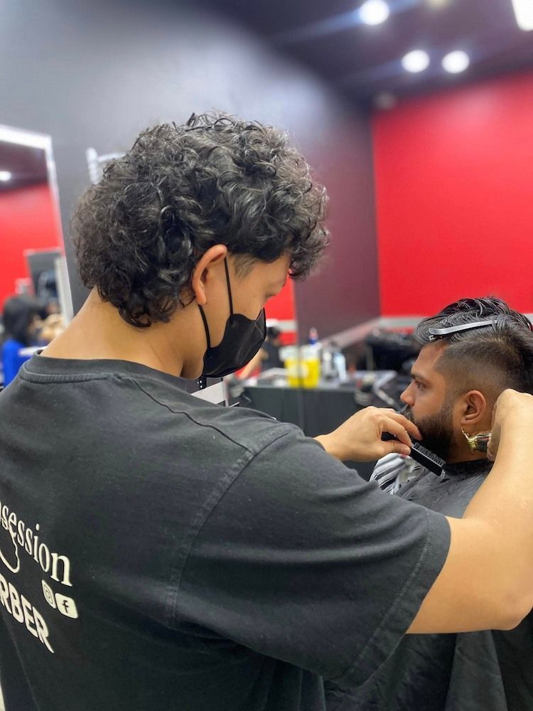A Man is Getting His Hair Cut by a Barber Wearing a Mask — Hair Obsession Barber in Nightcliff, NT