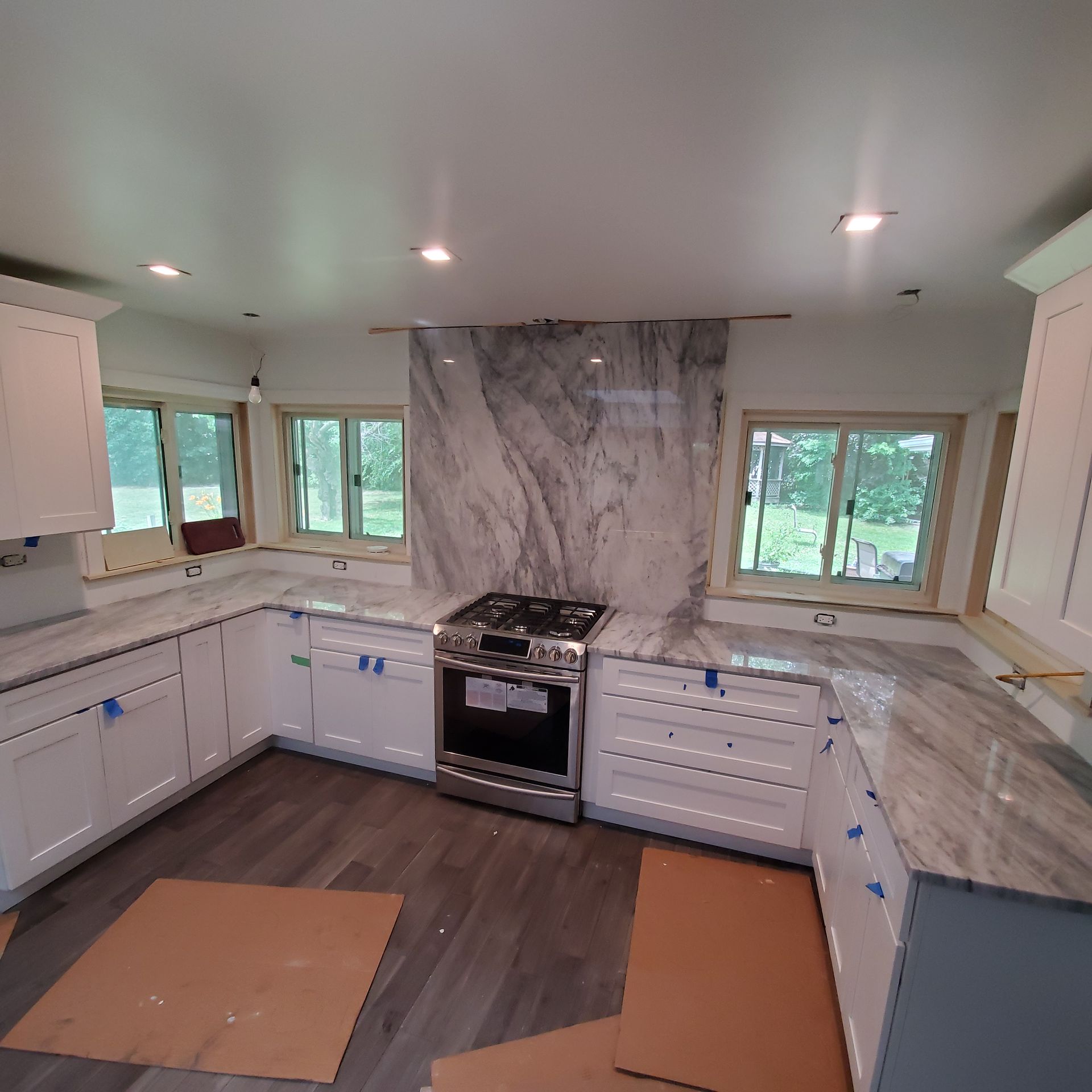 A bathroom with a sink , mirror , cabinets and drawers.