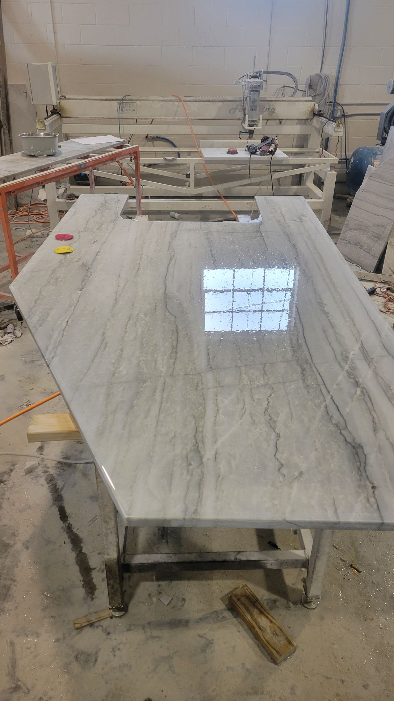 A kitchen with white cabinets and a large island with stools.