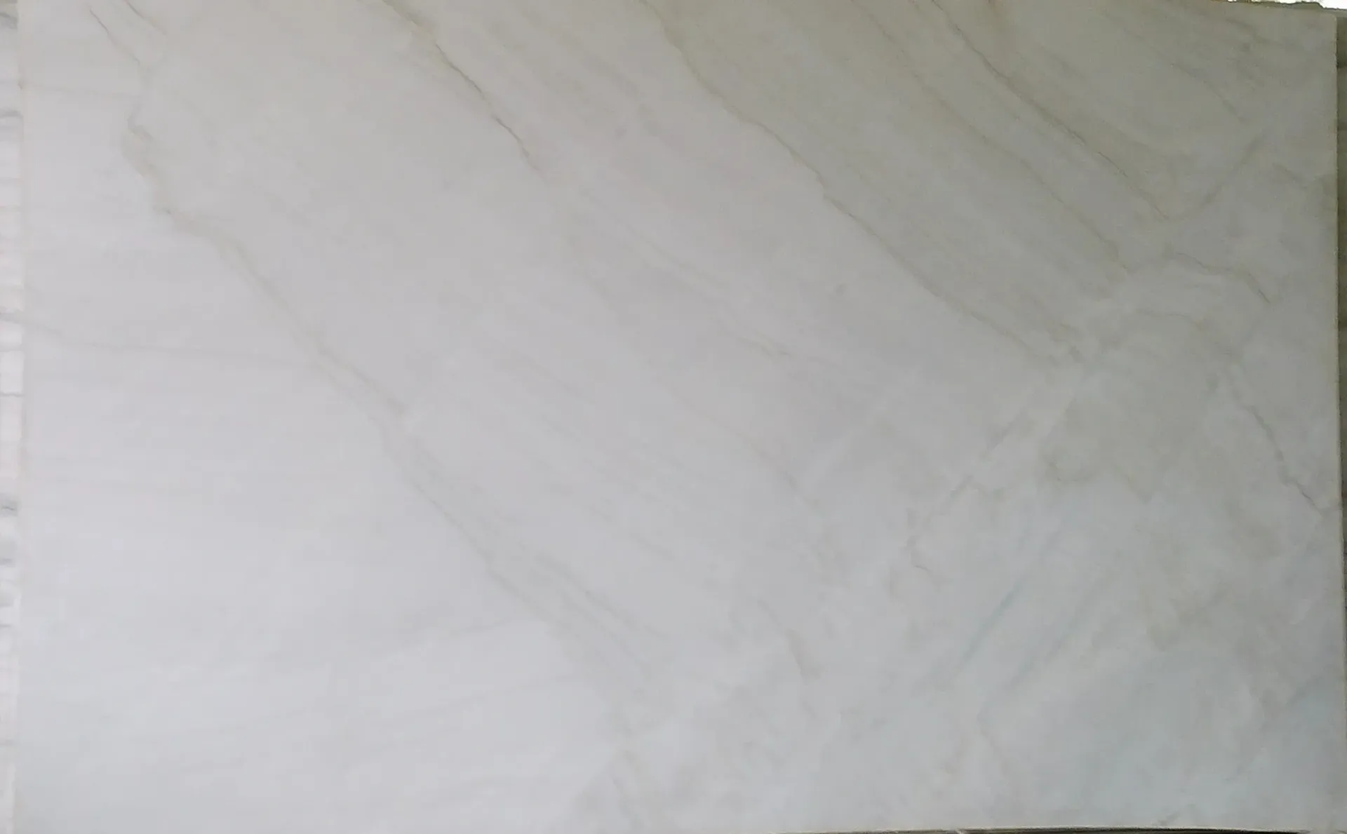 A white tile with a marble texture is sitting on a table.