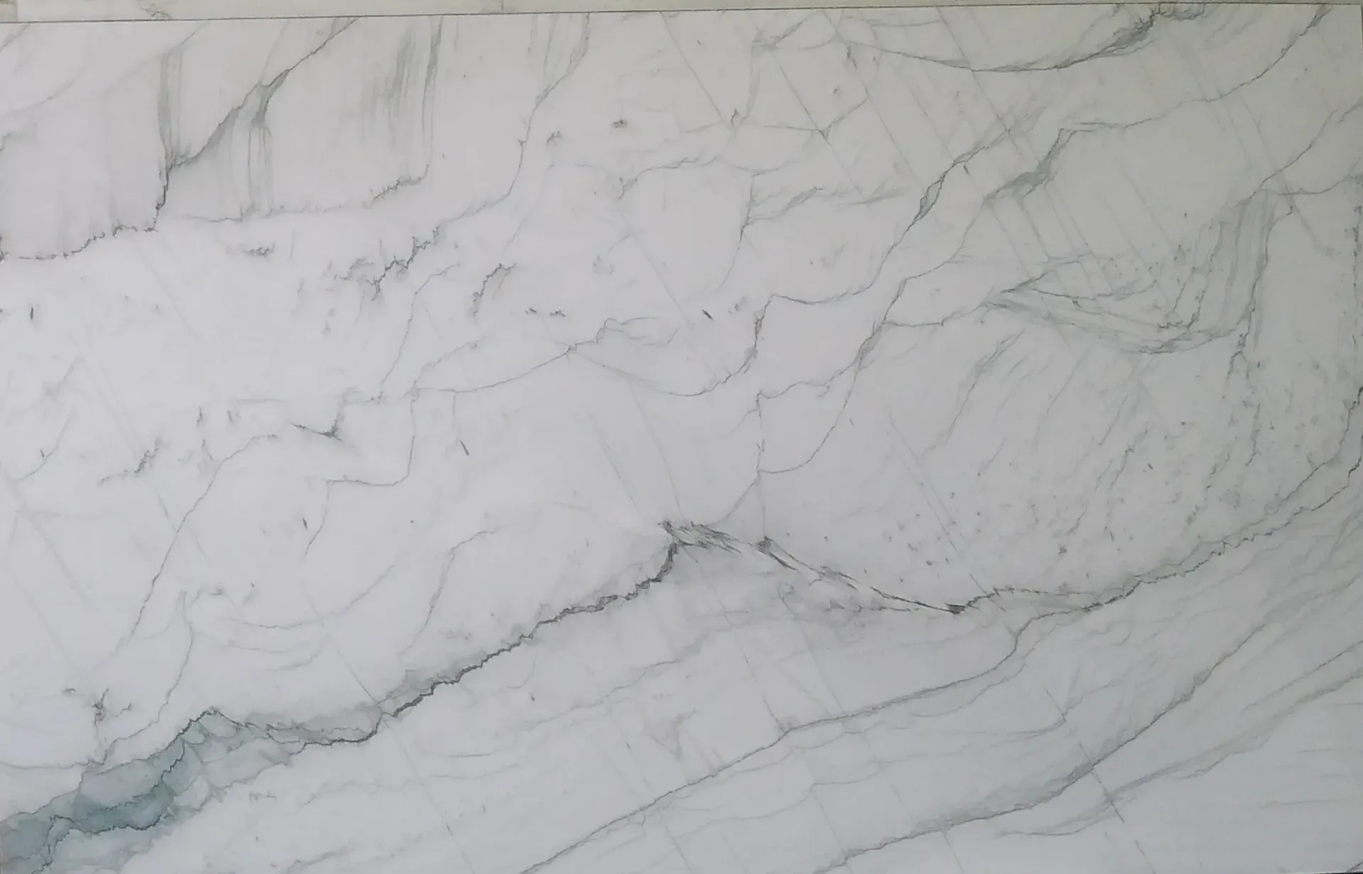 A close up of a white marble slab with a gray vein.
