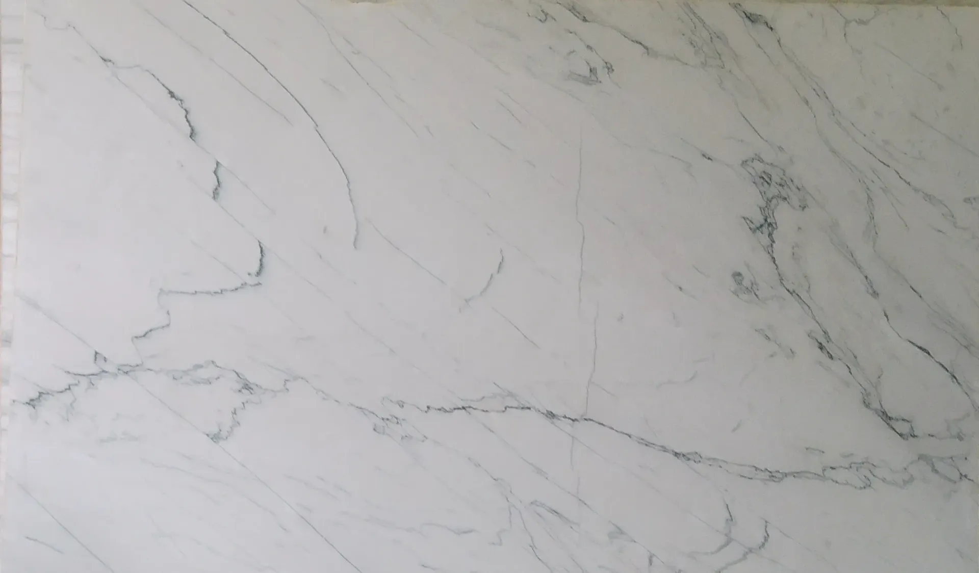 A close up of a white marble slab with black veins.