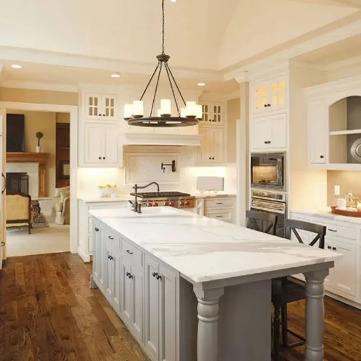 A kitchen with white cabinets and a large island