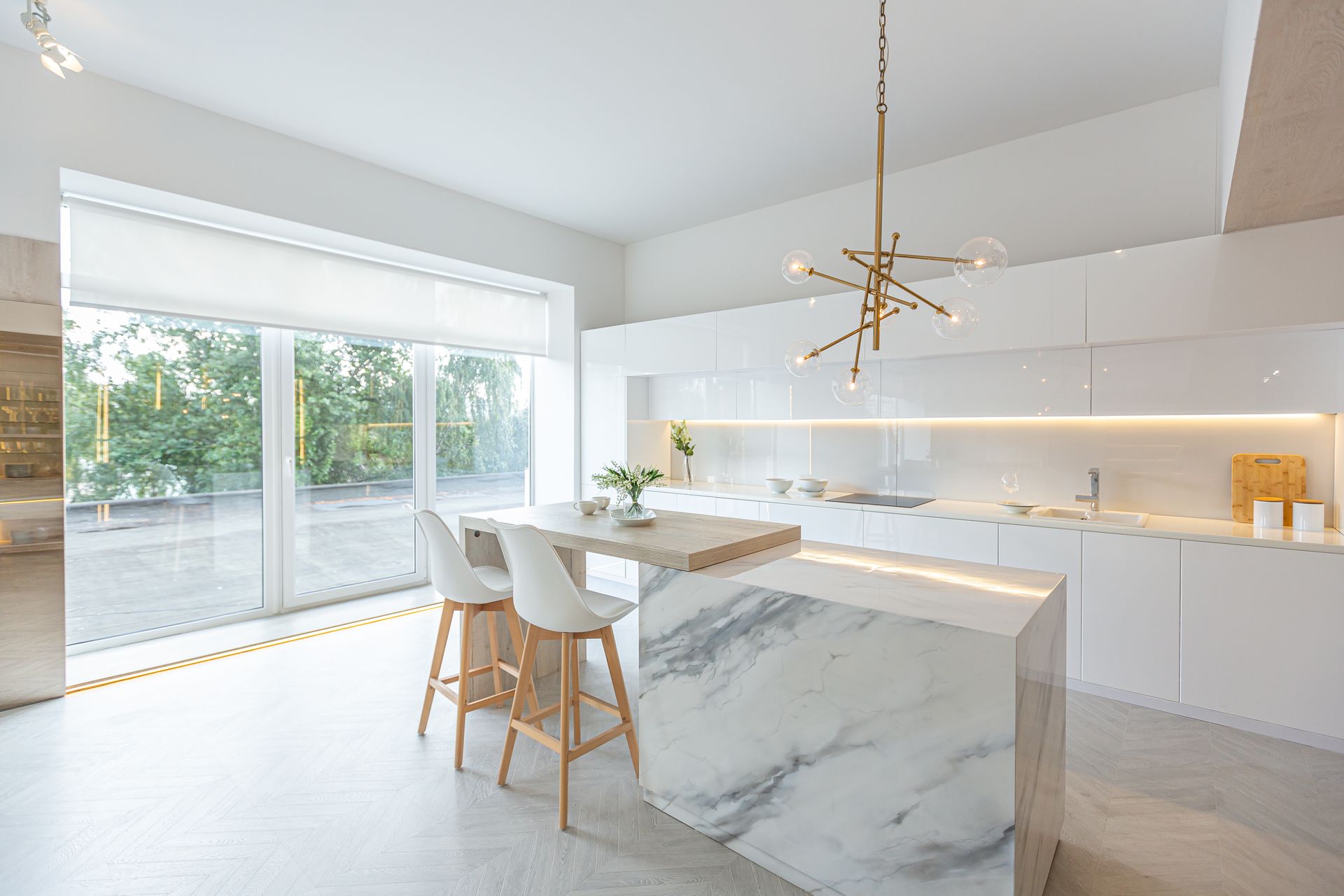 A kitchen with white cabinets and a marble counter top.