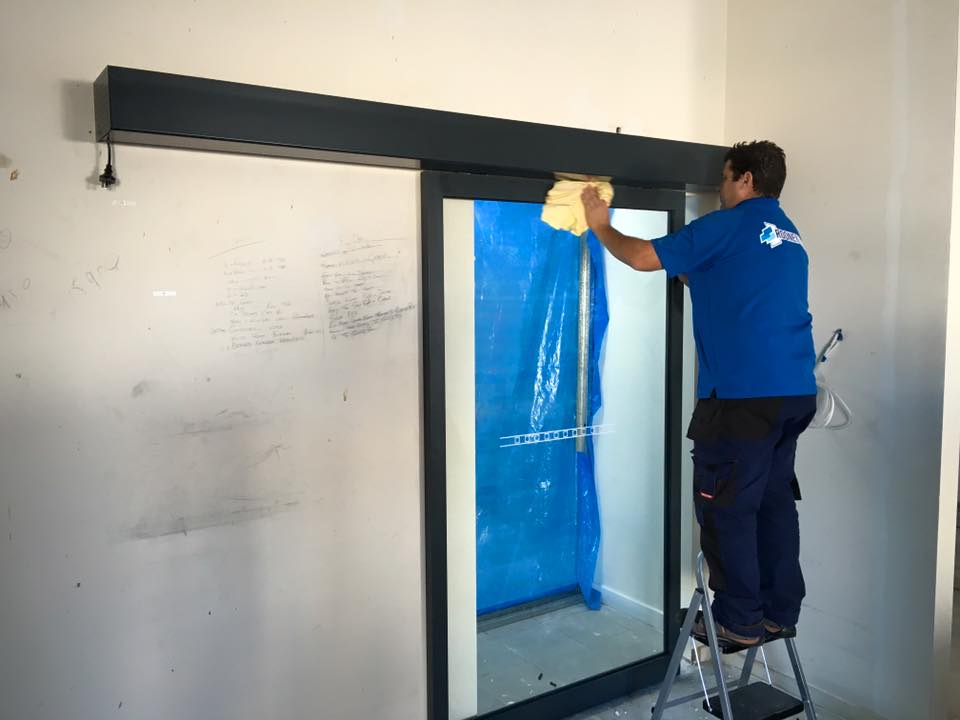 Man Cleaning Glass — Rooney Glass in Coffs Harbour, NSW
