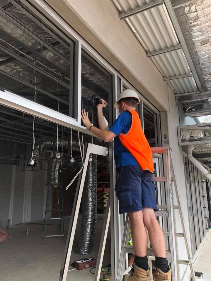 Man Installing Glass — Window Glass Repair and Installation in Coffs Harbour, NSW