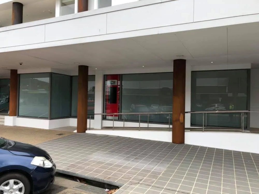A Blue Car is Parked in Front of a Building — Rooney Glass in Sawtell, NSW
