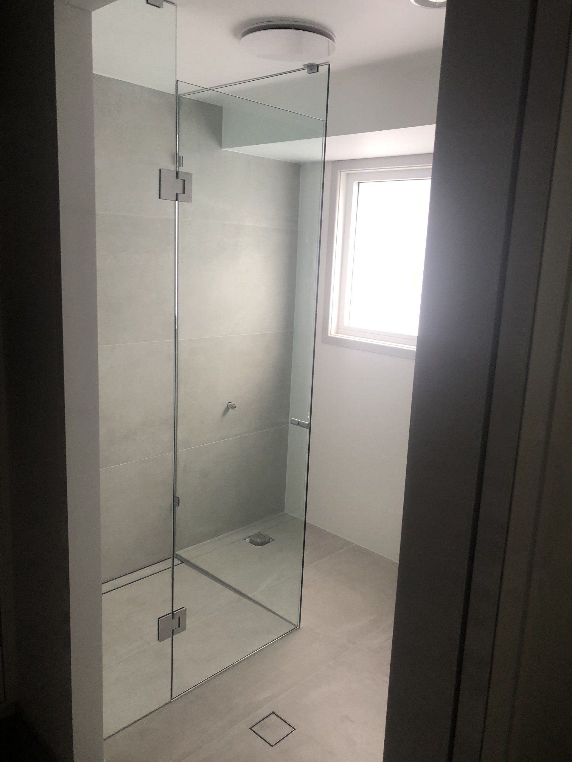 A Bathroom With a Walk in Shower and a Window — Rooney Glass in Coffs Harbour, NSW