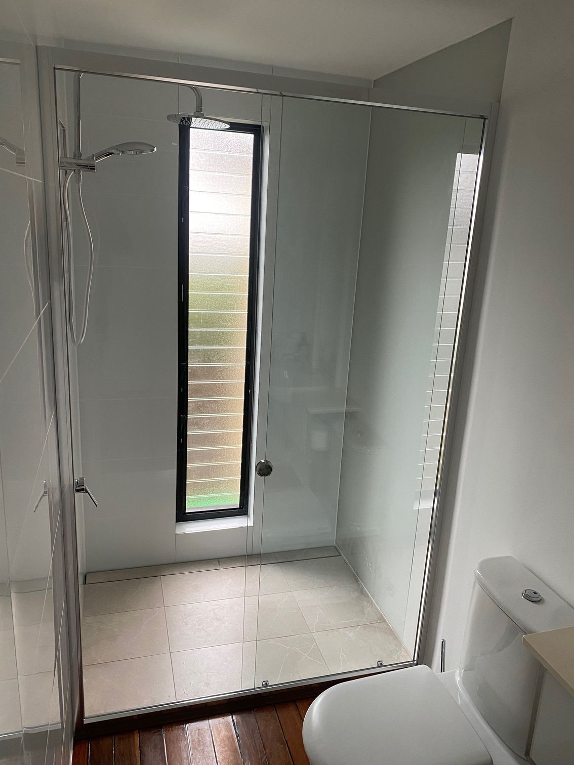 A Bathroom With a Toilet, Shower, and Window — Rooney Glass in Coffs Harbour, NSW