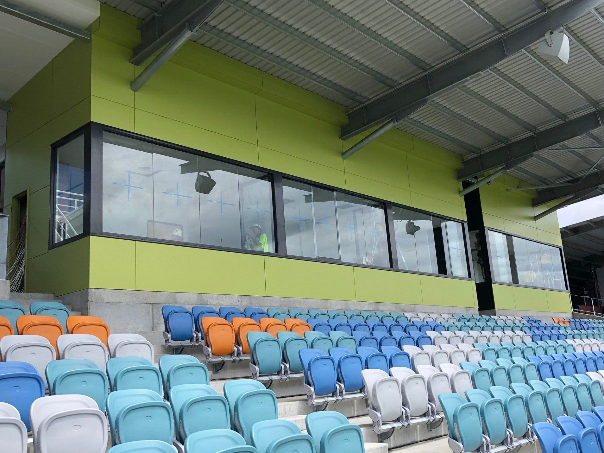 A Stadium With Rows of Colourful Seats and a Green Wall — Rooney Glass in Coffs Harbour, NSW