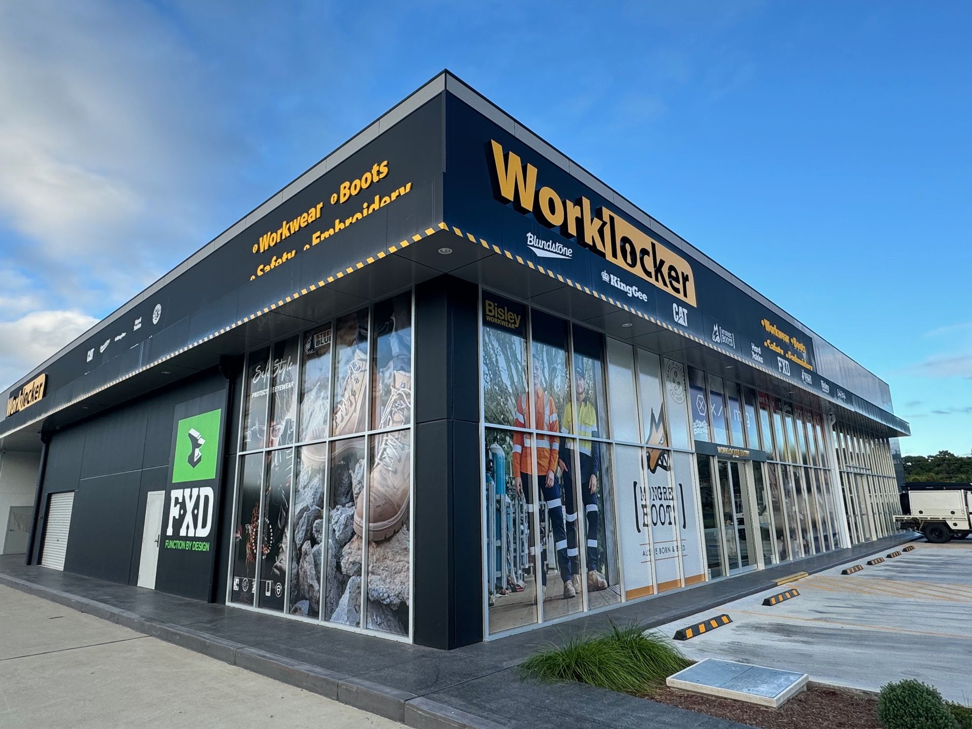 A Large Black Building With a Lot of Windows is a Worklocker Store — Rooney Glass in Coffs Harbour, NSW