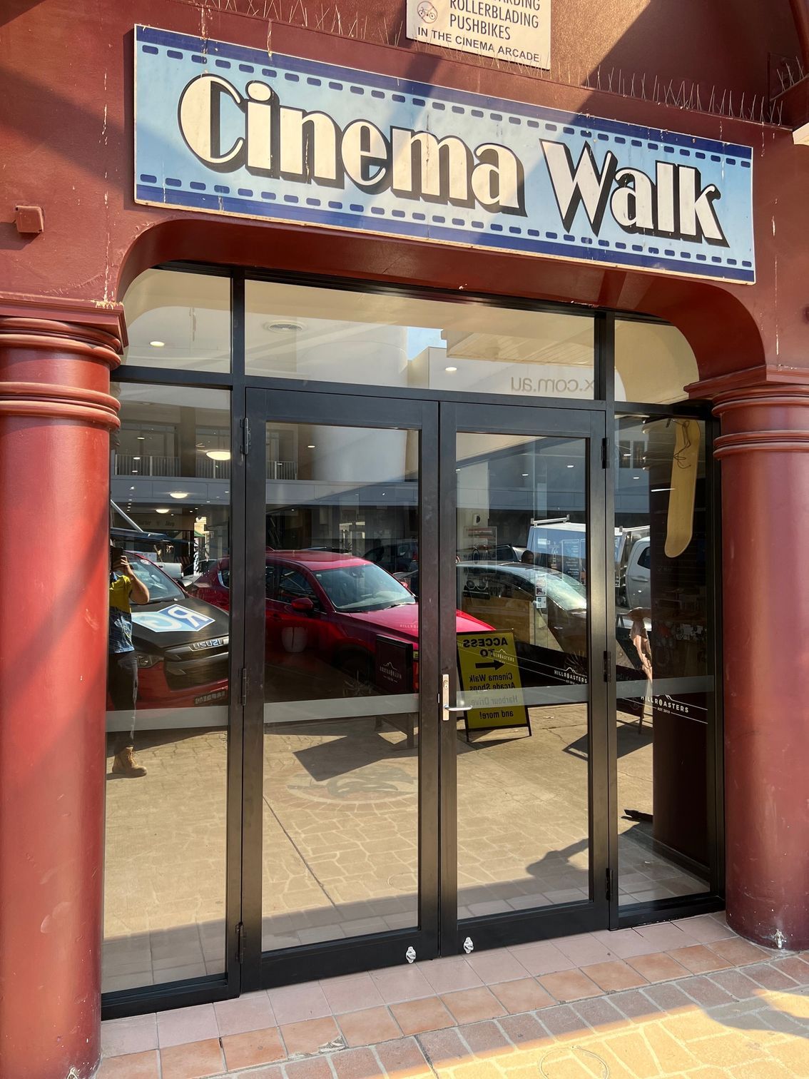 A Red Building With a Sign That Says Cinema Walk on It — Rooney Glass in Coffs Harbour, NSW