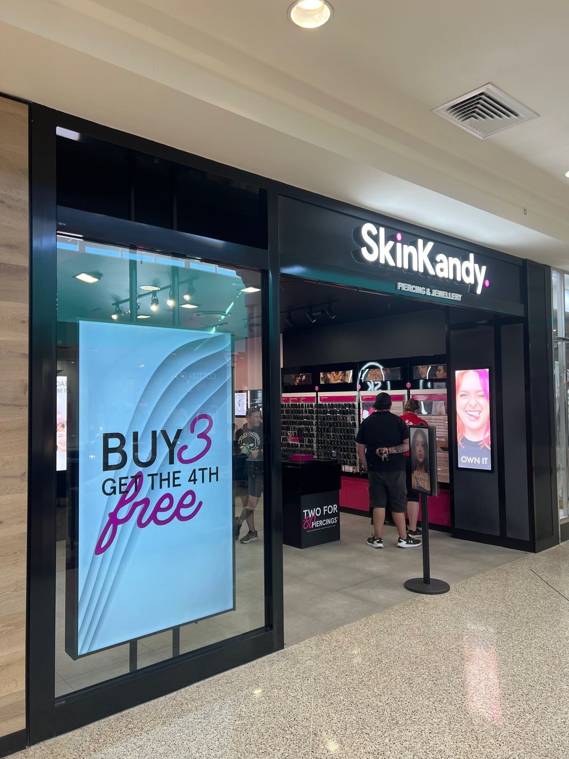 A Store Front With a Sign That Says Buy 3 Get the 4th Free — Rooney Glass in Coffs Harbour, NSW