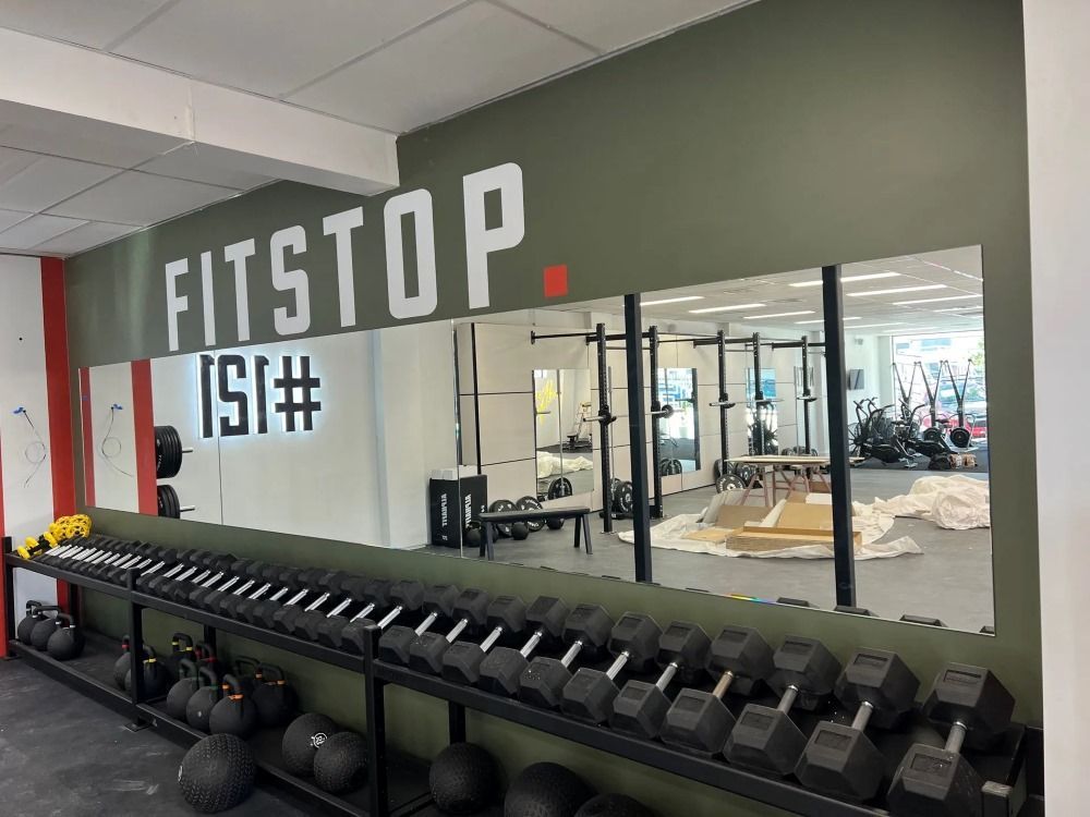A Gym With a Lot of Dumbbells and a Large Mirror — Rooney Glass in Woolgoolga, NSW