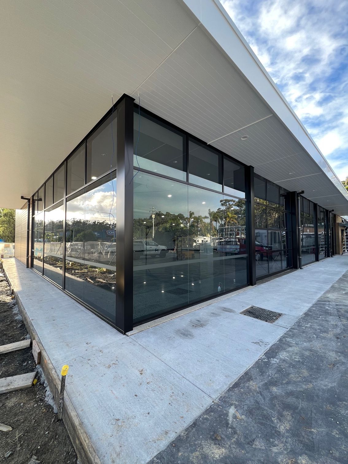 A Large Building With a Lot of Windows is Being Built — Rooney Glass in Coffs Harbour, NSW
