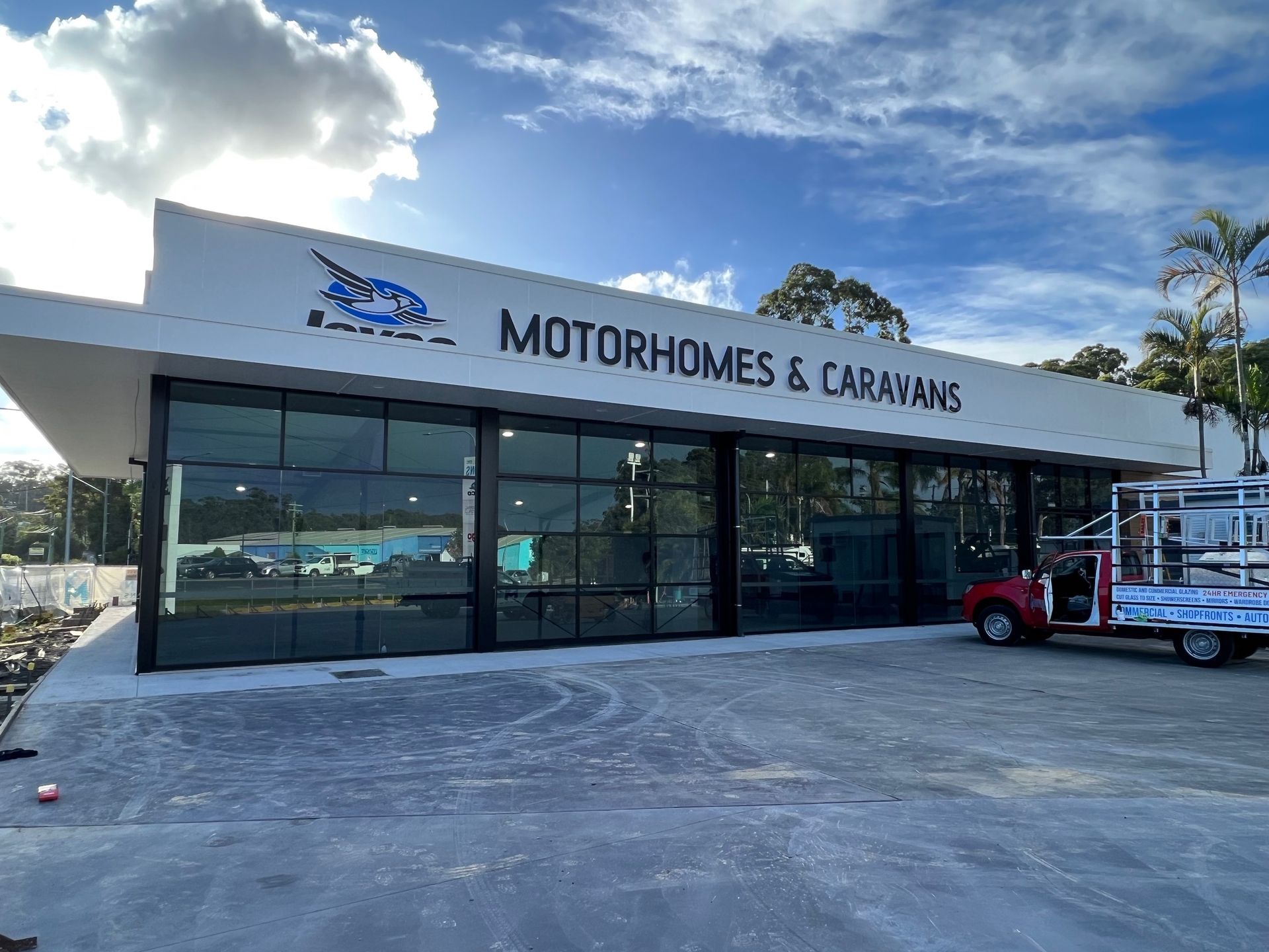 A Red Truck is Parked in Front of a Motorhomes and Caravans Building — Rooney Glass in Coffs Harbour, NSW