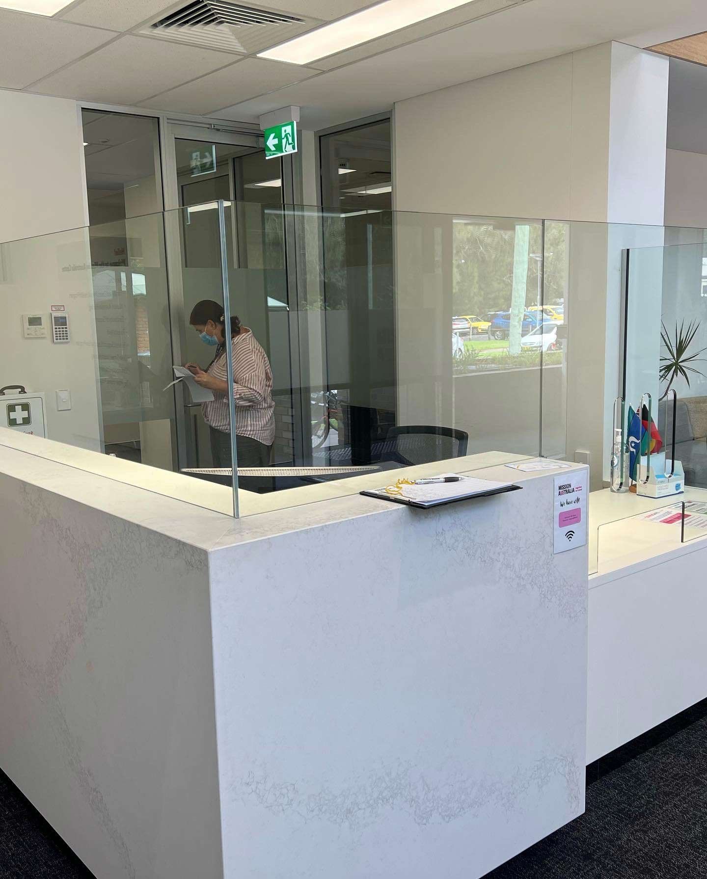 A Woman Is Standing Behind A Counter — Rooney Glass in Coffs Harbour, NSW