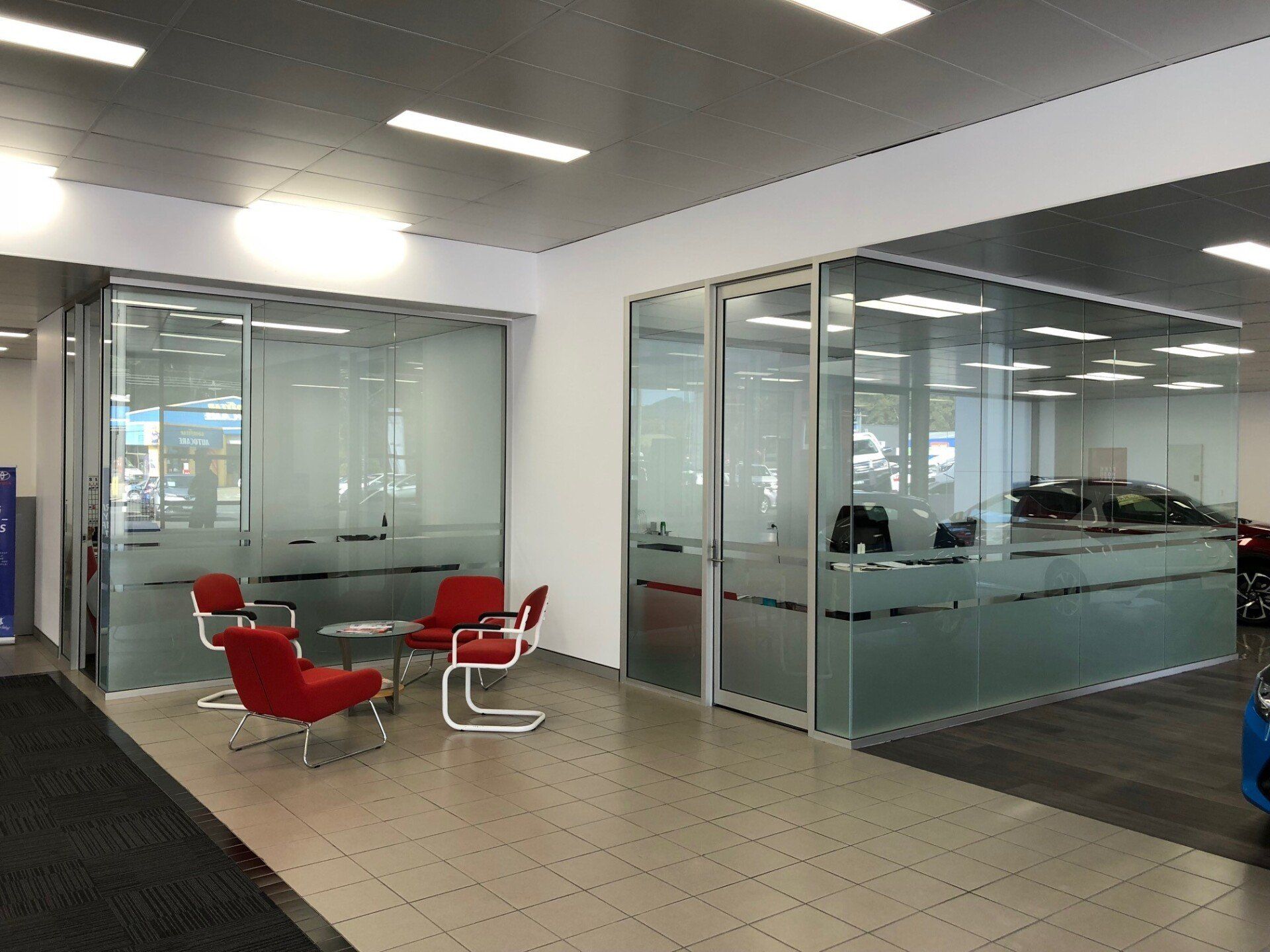 A Waiting Area in a Car Dealership With Chairs and a Table — Rooney Glass in Coffs Harbour, NSW