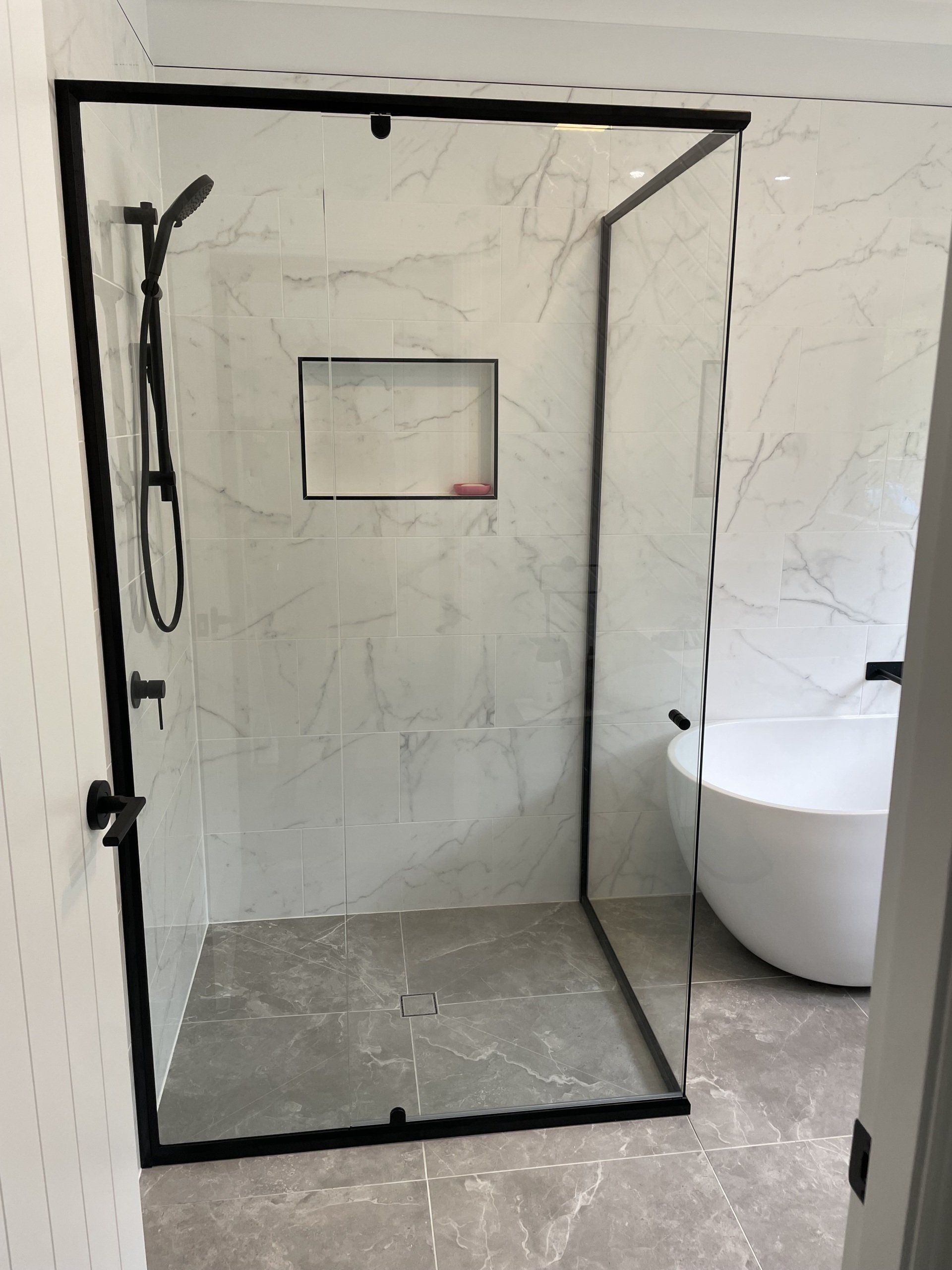 A Bathroom With a Walk in Shower and a Bathtub— Rooney Glass in Coffs Harbour, NSW