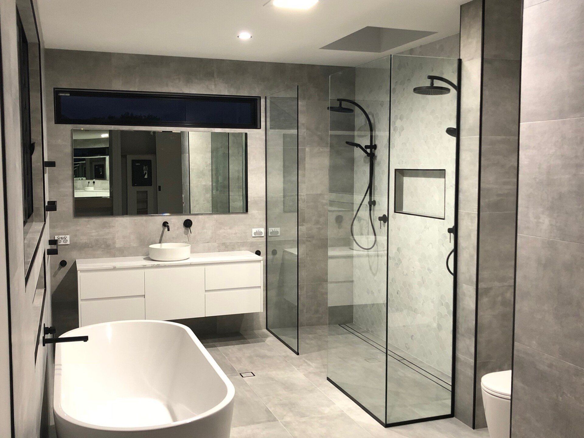A Bathroom With a Bathtub , Sink , Shower and Toilet — Rooney Glass in Coffs Harbour, NSW