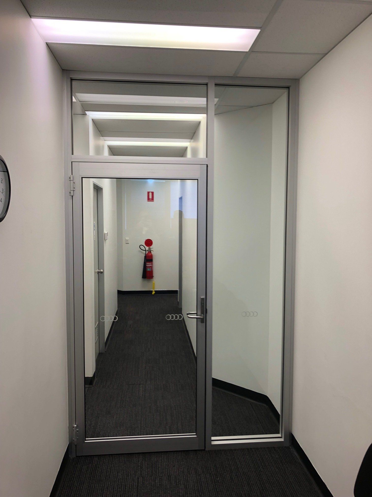 Hallway With A Glass Door And A Fire Extinguisher On The Wall — Rooney Glass in Coffs Harbour, NSW