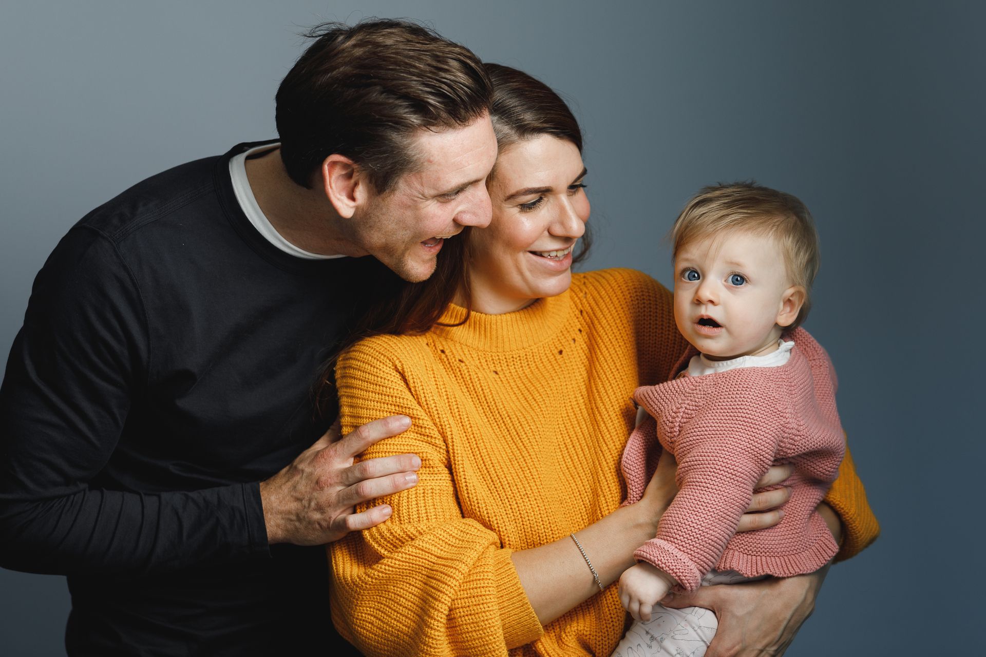 Ultrasound images of a fetus, including 3D and black-and-white views, arranged on a white and gray patterned blanket.