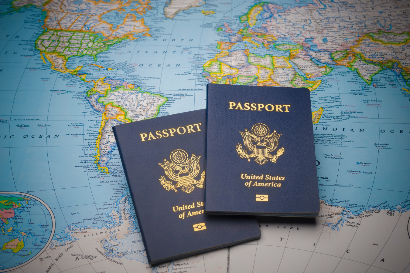 Two blue US passports on a world map.