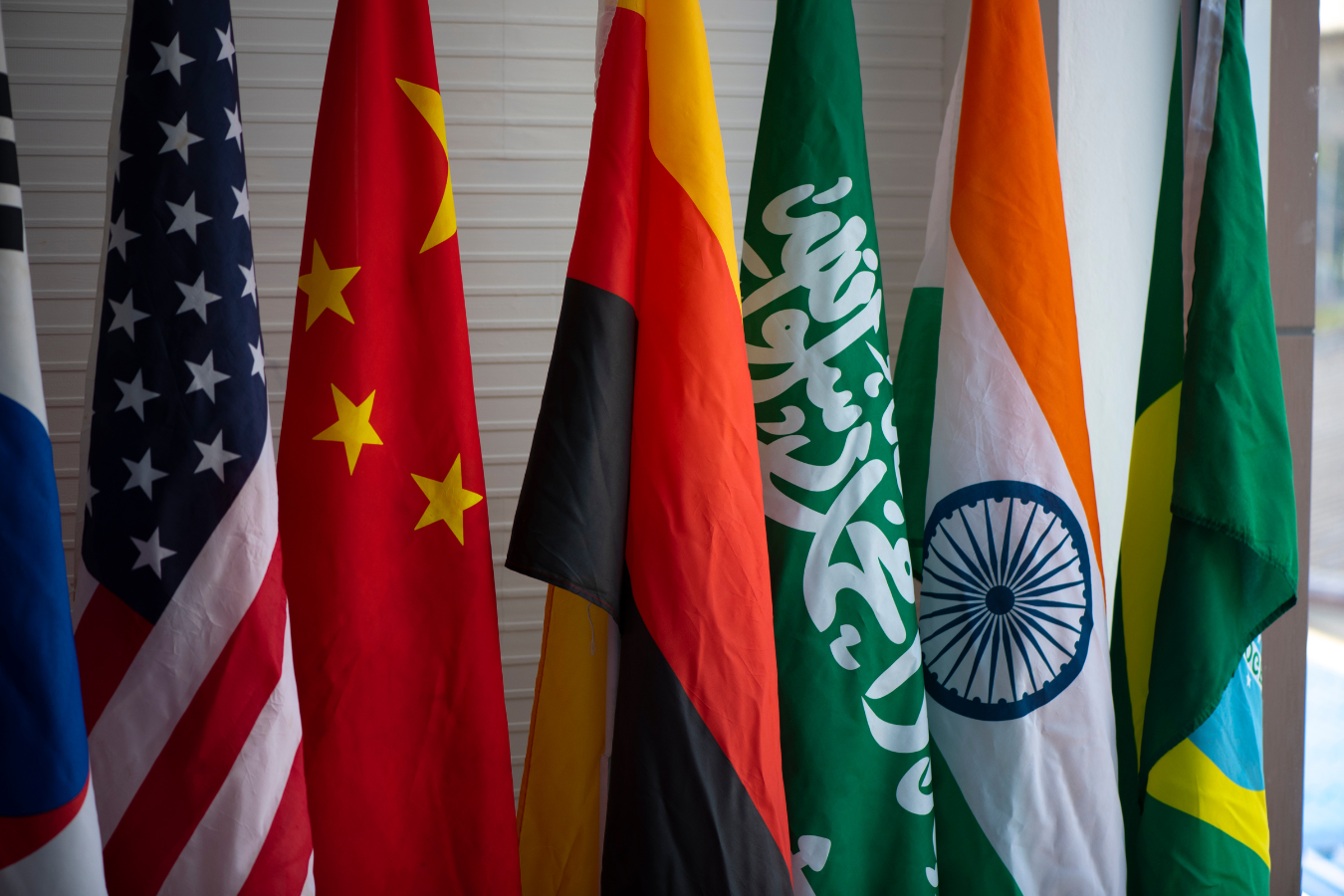 Flags of various nations, including China, Germany, Saudi Arabia, and India, displayed in a row.