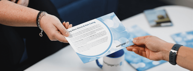 Hands passing a flyer with blue and white design.