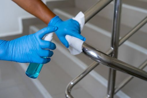 female hand using wet wipe and hand sanitizer spray