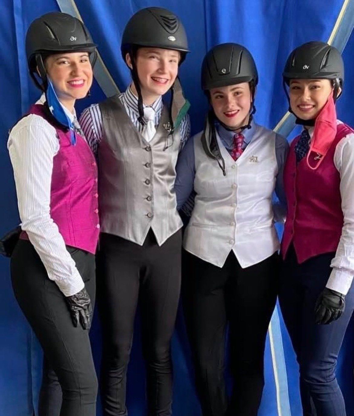 photo of four smiling Lenux Stables riders at horse show