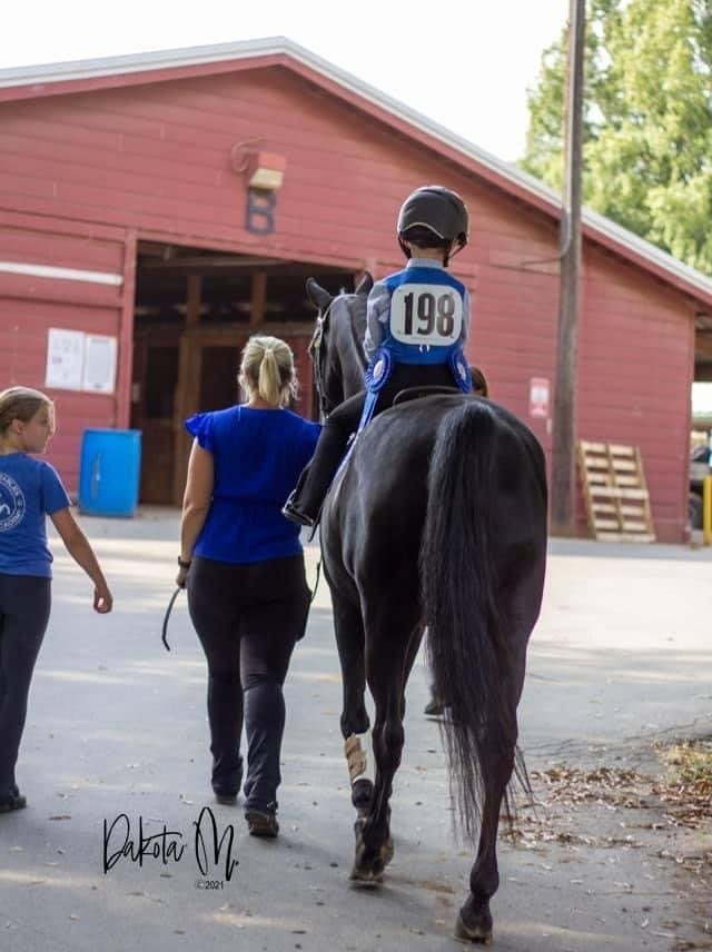photo of Lenux Stables academy rider heading toward stalls following horse show competition